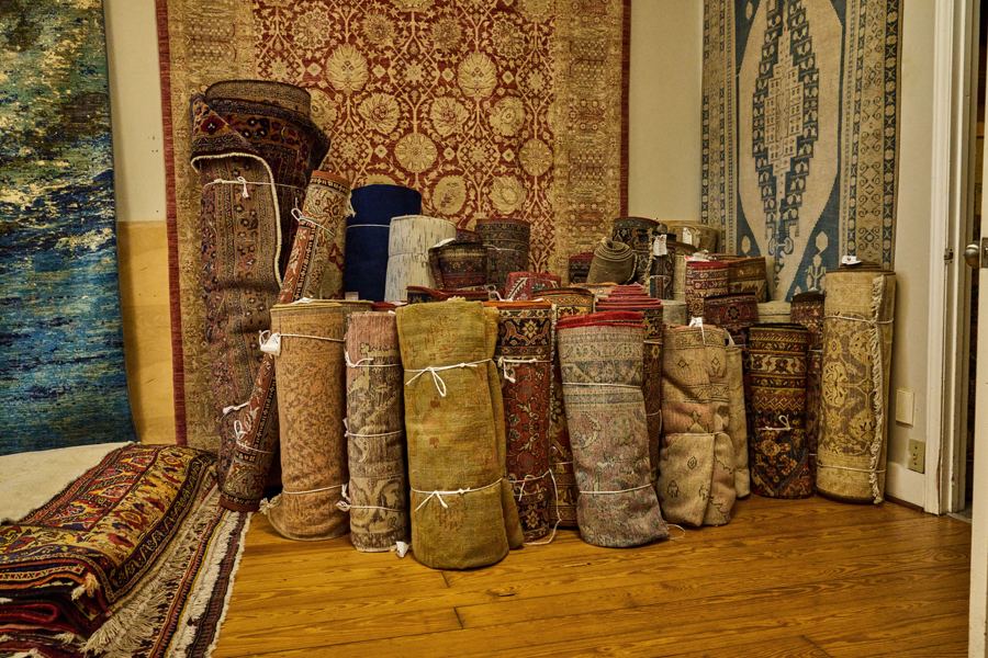Rolled rugs lined up in the gallery