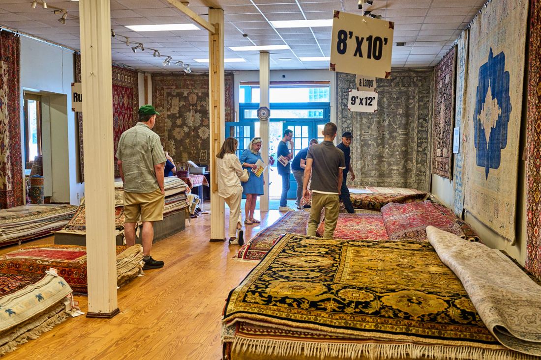The team showing rugs to guests