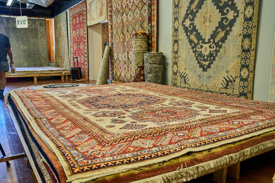 Hand-knotted rugs laid out on the gallery floor
