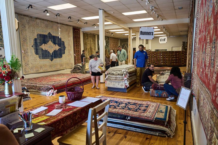 Guests browsing rugs during the 40th anniversary