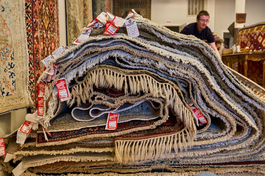 A stack of rugs with tags